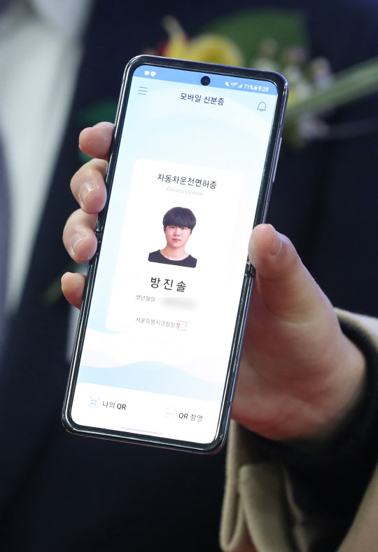 한국산업인력공단은 내달 2일부터 공단이 수행하는 국가자격시험에 모바일 신분증도 신분 확인 증명 수단으로 인정한다고 21일 밝혔다. 지난달 27일 서울 마포구 서부운전면허시험장에서 열린 모바일 운전면허증 개통식에서 예비 대학생 방진솔 씨가 모바일 운전면허증을 발급받은 뒤 들어 보이고 있다. <연합뉴스>